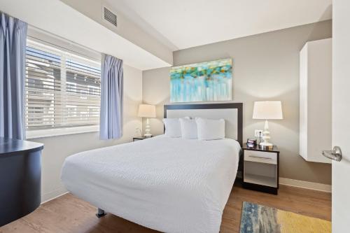 欧弗兰帕克WaterWalk- Kansas City- Overland Park的卧室设有一张白色大床和一扇窗户。