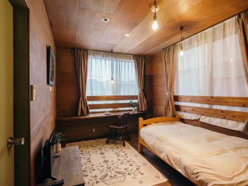 荒尾Noasobi Lodge 206- Vacation STAY 45777v的一间卧室配有一张床、一张书桌和一个窗户。