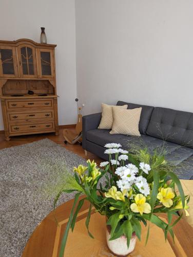 施内贝格Ursula的客厅配有沙发和鲜花桌