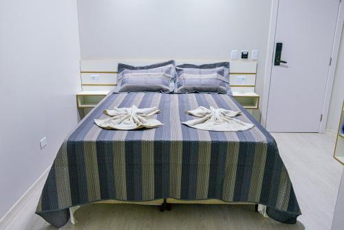 蓬塔波朗GUARANY HOTEL PONTA PORÃ的一间卧室配有一张带蓝色和绿色条纹毯子的床