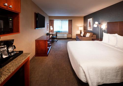 波特兰Silver Cloud Hotel - Portland的酒店客房设有一张大床和一间客厅。