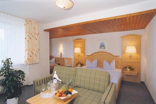 希尔兴巴赫金斯伯格海德宾馆的酒店客房,配有一张床和一张桌子,还有一碗水果