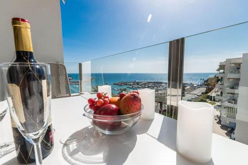 波多黎各Golden Sunny View Apartment的桌上的水果碗和一瓶葡萄酒