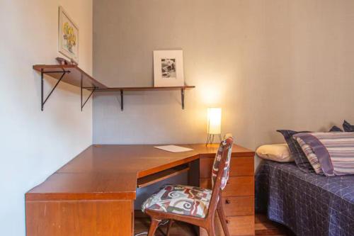 圣保罗Suíte em chalé na Represa的客房设有一张桌子、一张床和一张书桌。