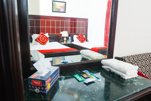 达卡Ali International Hotel的一张床铺和镜子的反射房间
