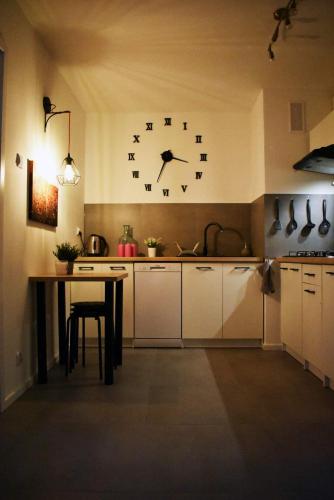 华沙Warszawa Centrum Pokoje的墙上的厨房配有大时钟