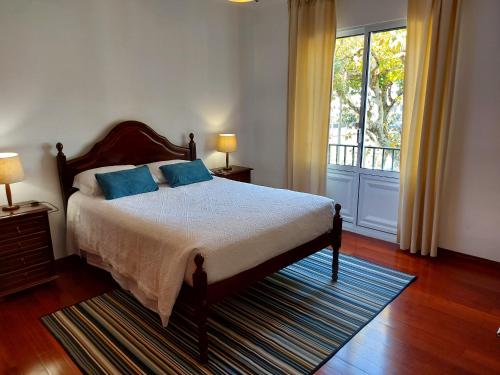 大里贝拉Beach & Surf的一间卧室配有一张带蓝色枕头的床和一扇窗户。