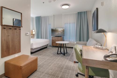 泰勒泰勒大学区驻桥套房酒店的配有一张床和一张书桌的酒店客房