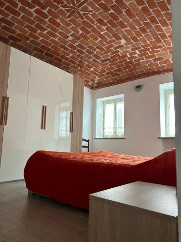 Cisterna dʼAstiTakápradalù的一间卧室设有两张床和砖砌天花板