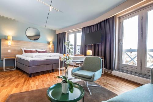 罗斯基勒Scandic Roskilde Park的一间卧室配有一张床、一张桌子和一把椅子