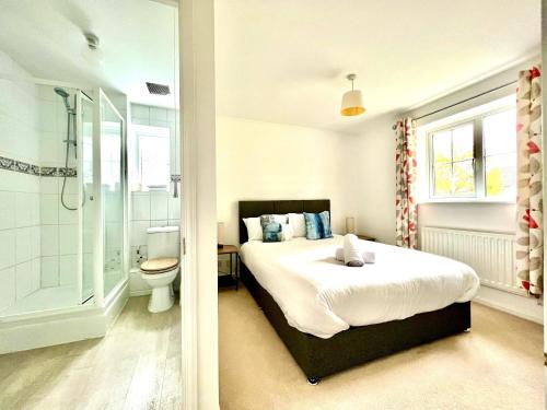 比斯特Comfortable 3 bedroomed house in Bicester的一间卧室设有一张床、淋浴和卫生间