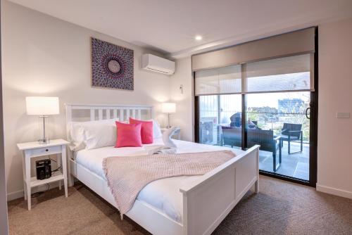 堪培拉The Hamptons - Lux 2 Bed 2 Bath, Pool - Central Location的卧室配有带红色枕头的白色床