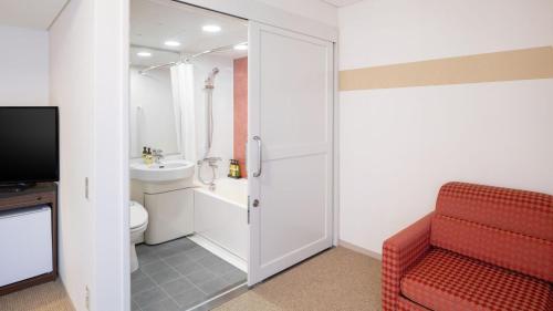 新泻ART 新泻站前酒店的一间带红色椅子和卫生间的浴室