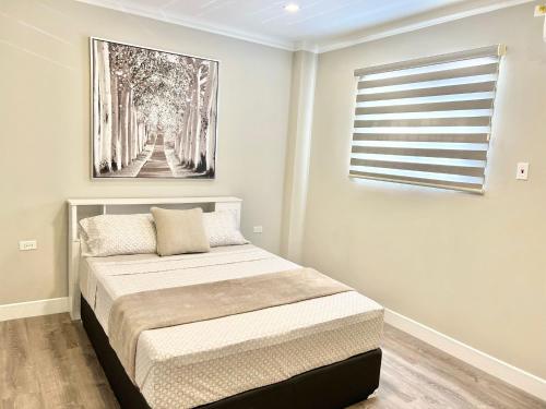 Saint HelenaSHAK Condos- Luxury, Functionality and Comfort的卧室配有一张床,墙上挂有绘画作品