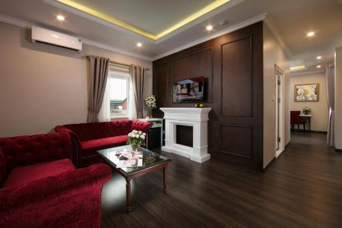 河内Flora Centre Hotel & Spa的客厅设有红色的沙发和壁炉