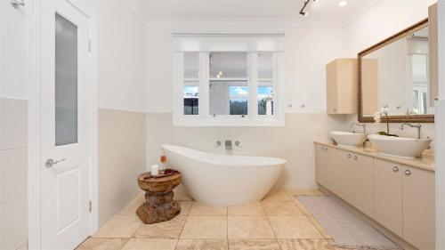 DaptoCowley House的白色的浴室设有2个盥洗盆和1个浴缸。