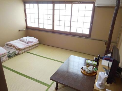 大阪Imazato Ryokan - Vacation STAY 02530v的一间设有床铺和桌子的房间