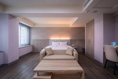 台中市美之旅商务饭店的酒店客房,配有床和沙发
