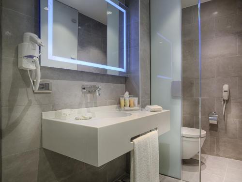 伊兹密尔TAV Airport Hotel Izmir的浴室配有白色水槽和卫生间。