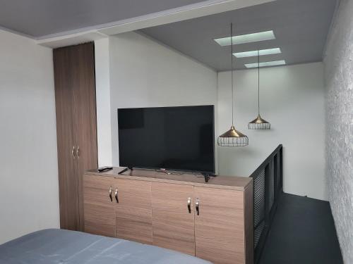 马尼萨莱斯Casa Azul的一间卧室,在橱柜上配有一台平面电视