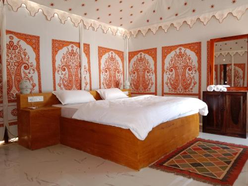 KūriSunny Desert Camp的一间配备有床铺的卧室,位于一个橙色和白色壁纸的房间