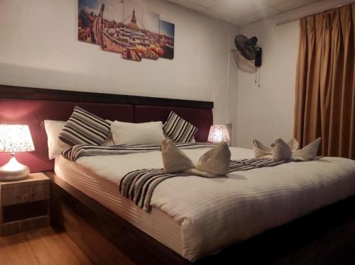 KawasotiThe Glasshouse Hotel的一间卧室配有一张大床和两个枕头