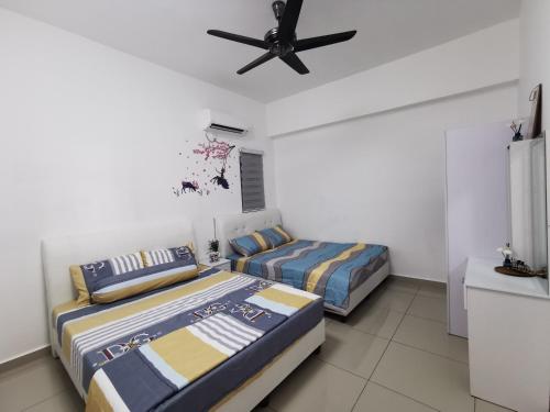 实兆远Coco HomeStay 旅人の家@The Venus Sitiawan Perak的一间卧室配有两张床和吊扇