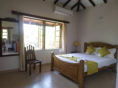 卡兰古特Palmeiral BeachVilla的卧室配有床、椅子和窗户。