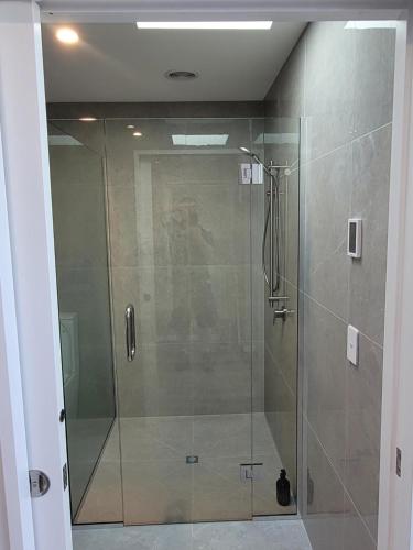 Diamond HarbourTaimana Boutique Motel的浴室里设有玻璃门淋浴