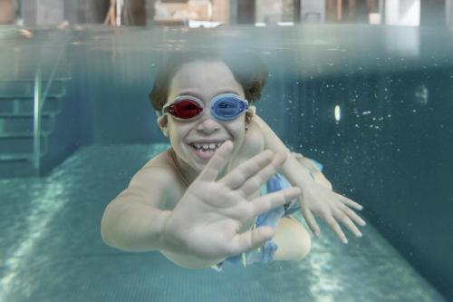 马尔邦Gorfion Familotel的穿着眼镜在游泳池里的年轻女孩