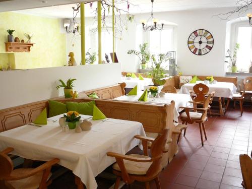 巴特尚道尔布格里赫特酒店的餐厅设有白色的桌椅和窗户。