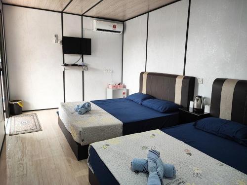 巴东勿刹Padang Besar Rainbow Cabin Homestay的一间设有两张床和一台电视的房间