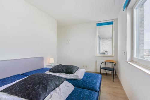布雷斯肯斯Hello Zeeland - Appartement Port Scaldis 03-071的一间卧室设有两张床和窗户。