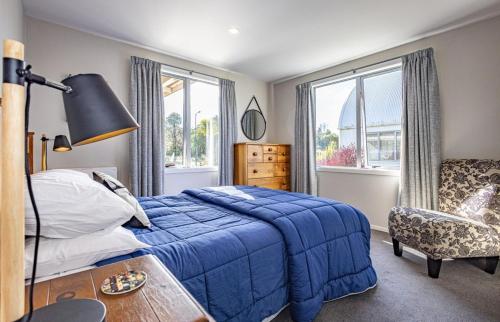 国家公园Ruapehu Retreat的一间卧室配有蓝色的床和椅子