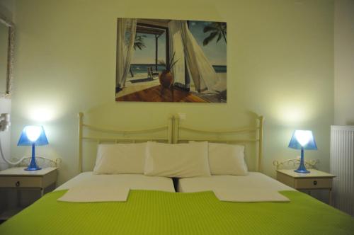 佩弗奇ARTEMIS ROOMS的一间卧室配有一张带两盏灯的绿床。