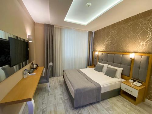 安塔利亚Vista Family Hotel Konyaaltı的配有一张床和一张书桌的酒店客房
