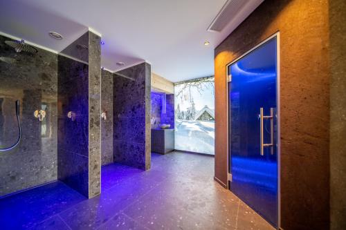 蒙圭尔福希霍夫酒店的一间带蓝色淋浴和玻璃门的浴室