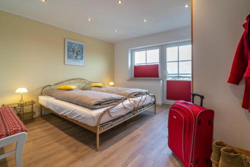 博帕德Franze´s Haus - mit Rhein- & Burgenblick的一间卧室配有一张床和一个红色的行李箱