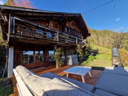 RougemontGstaad Paradise View Chalet with Jacuzzi的房屋前方设有一张沙发和一张桌子