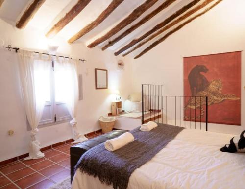 BlancaCasa rural con jacuzzi y chimenea en paraje único - La Casa del Pino的一间卧室设有一张大床和一个窗户。