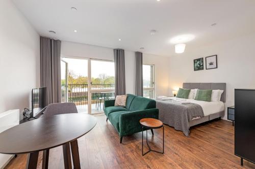 伦敦Stayo Apartments Barking Wharf的酒店客房配有床、沙发和桌子。