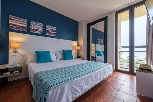 伊斯兰蒂拉Estival Islantilla的一间卧室配有一张带蓝色墙壁的大床