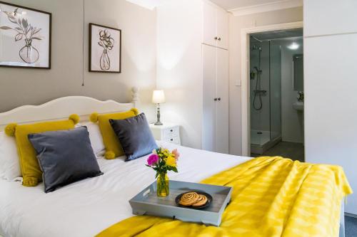 约克古德姆盖特公寓酒店的一间卧室配有白色的床和黄色及蓝色枕头