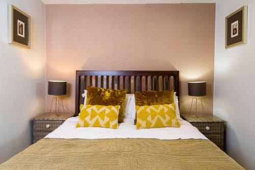 约克古德姆盖特公寓酒店的一间卧室配有一张带黄色枕头的床和两盏灯。