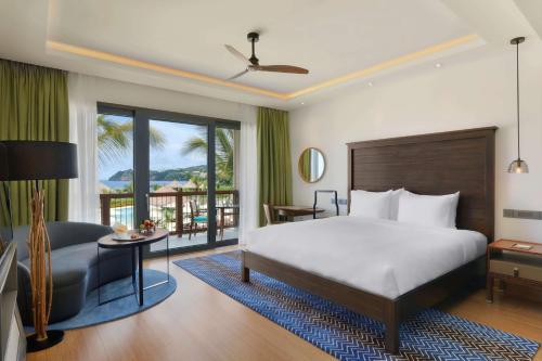 PortsmouthInterContinental Dominica Cabrits Resort & Spa, an IHG Hotel的一间卧室配有一张床和一张桌子及椅子