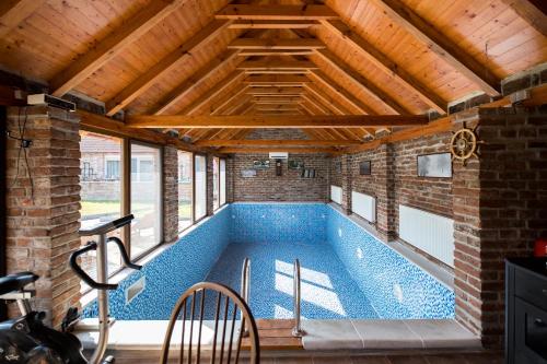 AljmašRiver Side的一座带木制天花板的别墅内的游泳池