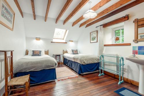 BoarhillsThe Granary - Quaint & Cosy Cottage的一间卧室配有两张床和水槽