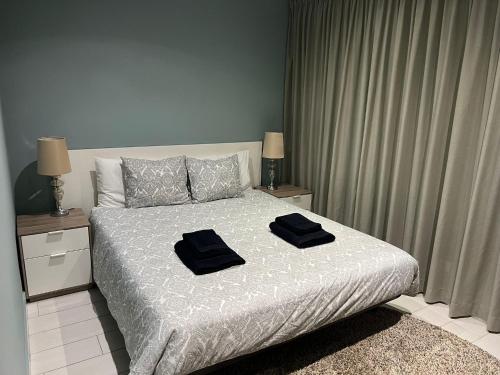 维拉摩拉T3 Vilamoura的一间卧室配有一张带两张黑色毛巾的床