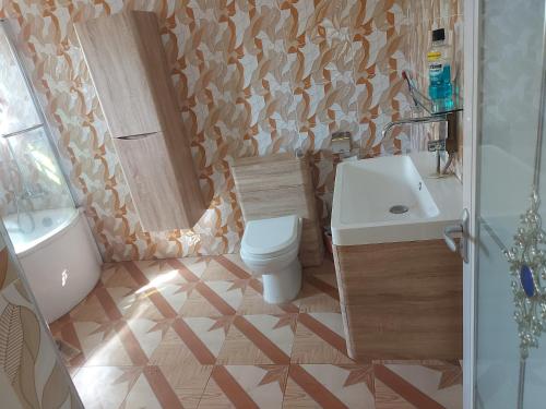 库马西Masbella Airbnb的浴室配有卫生间、盥洗盆和浴缸。