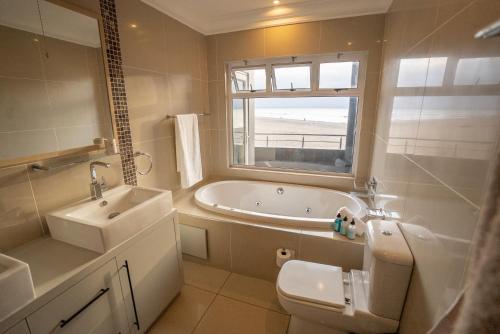 LangstrandDeja Blue Beachfront Villa, Newly renovated的带浴缸、盥洗盆和卫生间的浴室